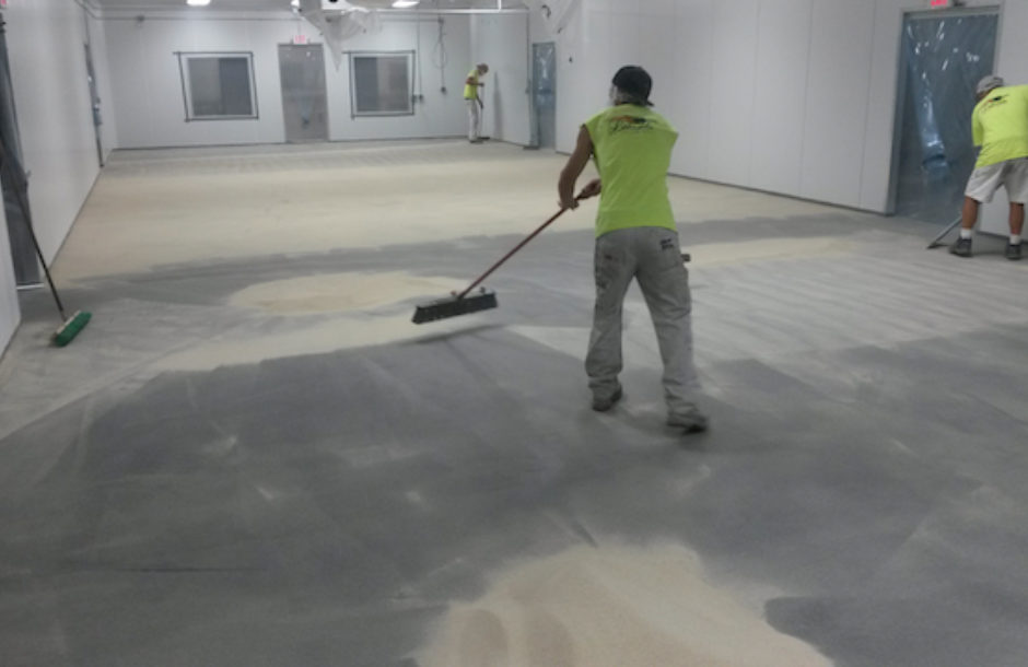Worker painting grey color to the floor